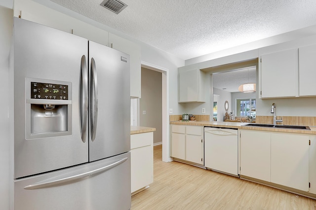 kitchen featuring dishwasher, white cabinetry, stainless steel fridge with ice dispenser, and sink