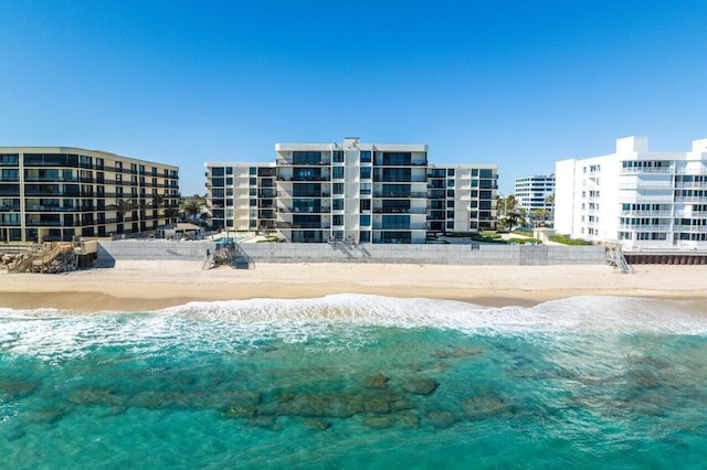 view of swimming pool with a water view and a beach view