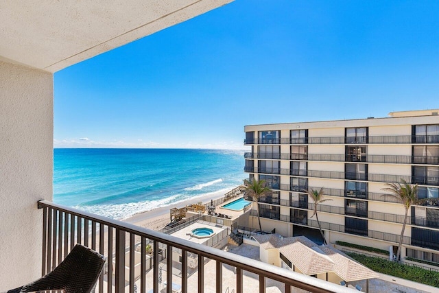 balcony with a water view and a beach view