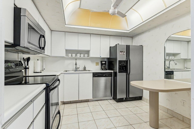 kitchen with white cabinets, appliances with stainless steel finishes, ceiling fan, and sink