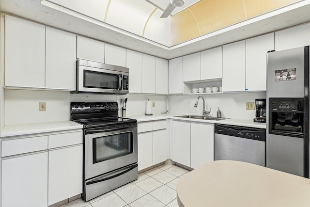 kitchen featuring backsplash, stainless steel appliances, sink, light tile patterned floors, and white cabinets