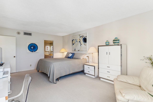 bedroom featuring light colored carpet and a textured ceiling