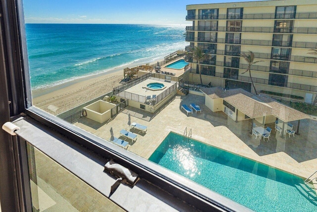 drone / aerial view with a water view and a beach view