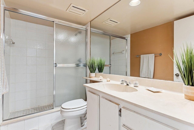 bathroom with toilet, vanity, tile patterned floors, and walk in shower