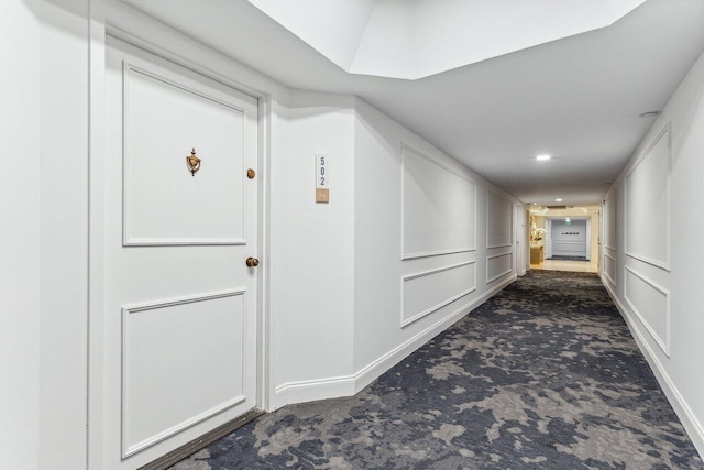 hall featuring dark colored carpet