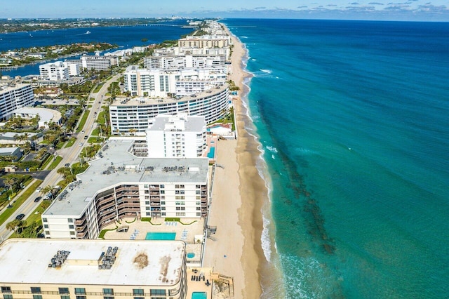 birds eye view of property featuring a water view and a beach view