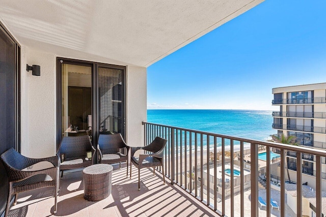 balcony with a water view and a beach view