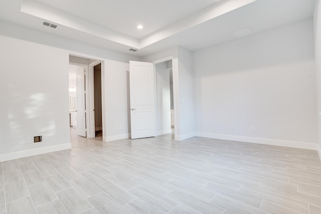 unfurnished room featuring a raised ceiling