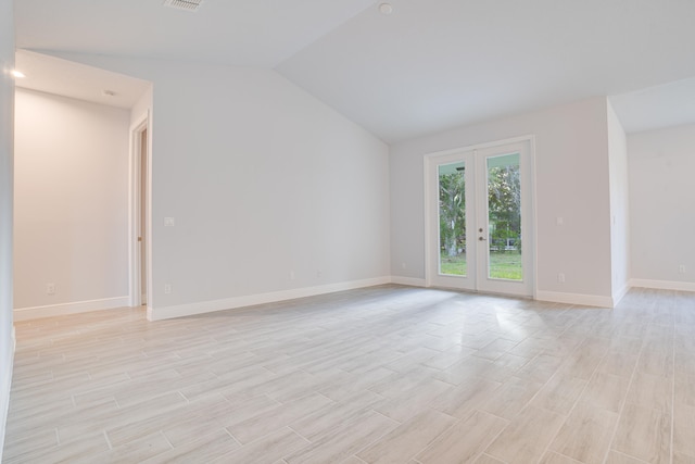 empty room with french doors and vaulted ceiling