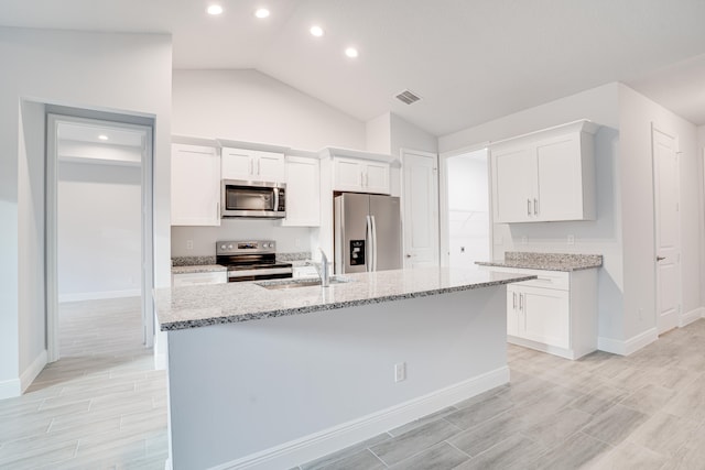 kitchen featuring white cabinets, vaulted ceiling, and stainless steel appliances