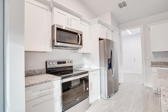 kitchen featuring white cabinets, light stone countertops, and stainless steel appliances