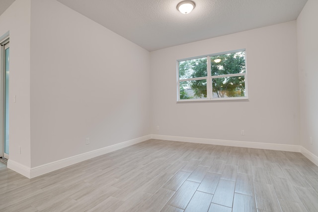 empty room featuring light hardwood / wood-style floors and a textured ceiling