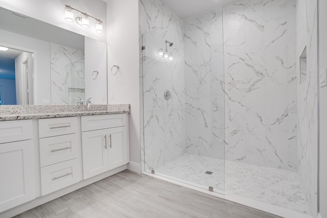 bathroom with vanity, tile floors, and a tile shower