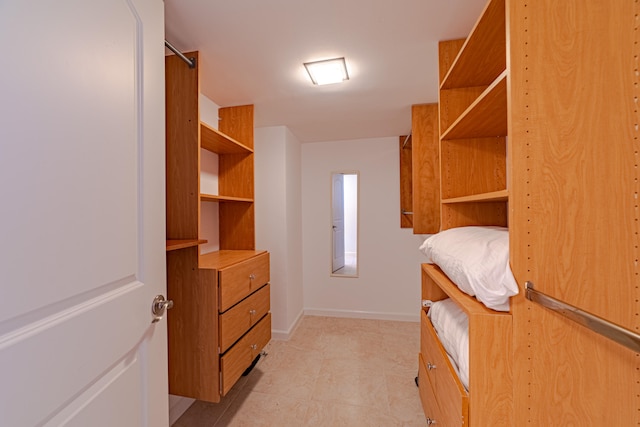 walk in closet with light tile flooring