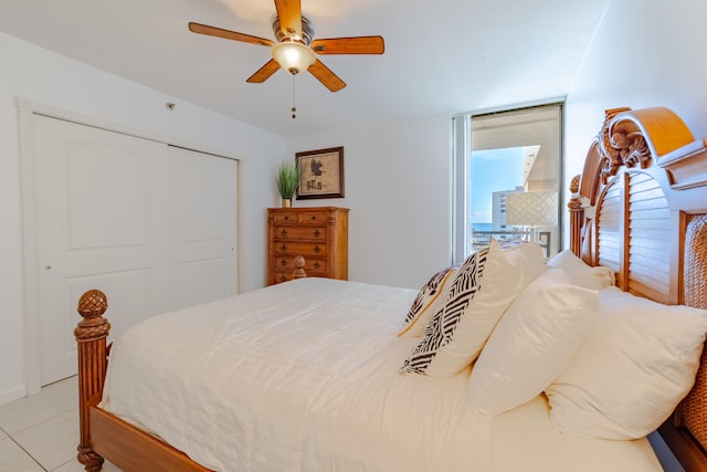 bedroom with light tile flooring, a closet, and ceiling fan