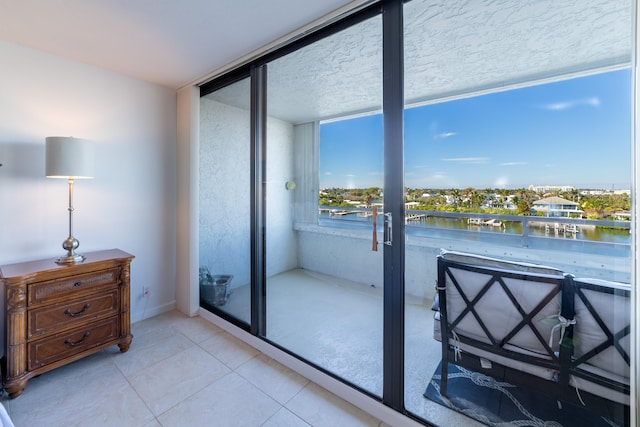 interior space featuring floor to ceiling windows, a water view, and multiple windows