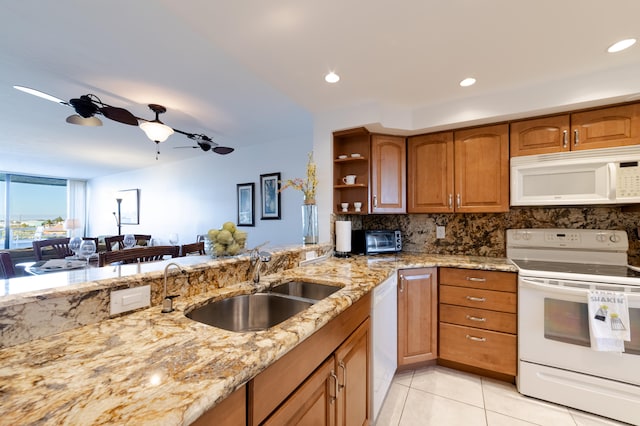 kitchen with white appliances, sink, ceiling fan, light stone counters, and tasteful backsplash