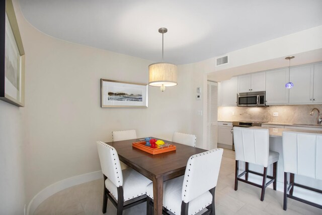 dining space with sink and light tile patterned floors