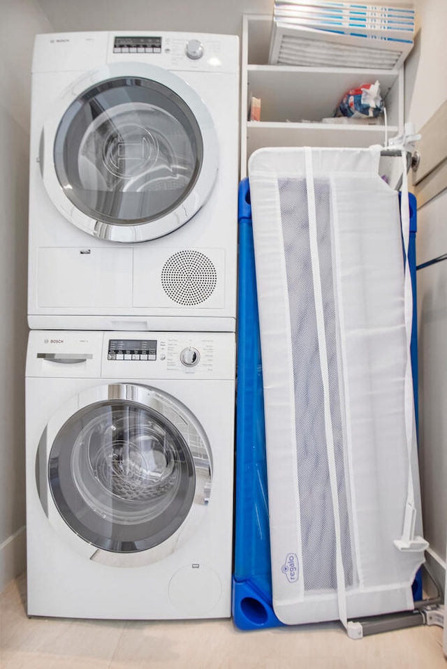 laundry area featuring stacked washer / drying machine