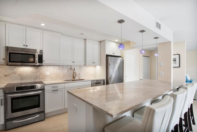 kitchen with visible vents, light stone countertops, tasteful backsplash, appliances with stainless steel finishes, and a sink