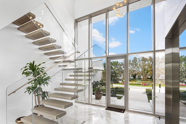 staircase with floor to ceiling windows and a high ceiling