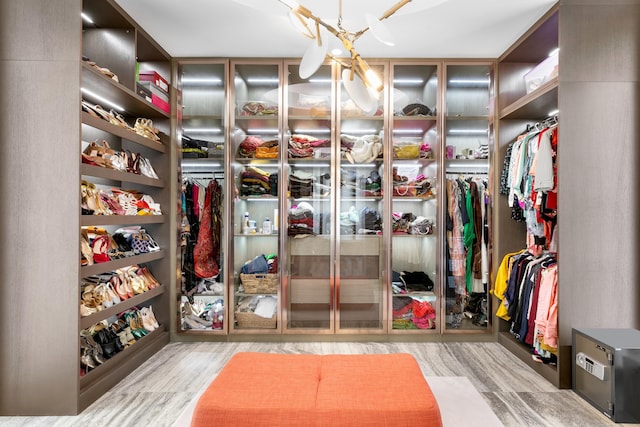 walk in closet with a chandelier