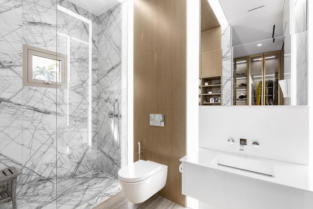 bathroom featuring a shower with door, toilet, and tile walls