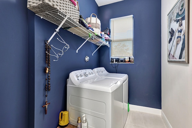 laundry room featuring washing machine and clothes dryer and light tile floors