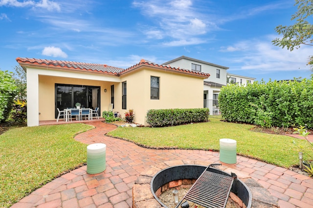 rear view of house with a lawn and a patio