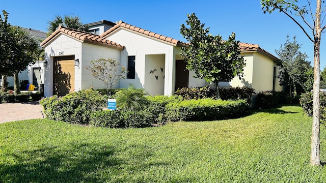 mediterranean / spanish-style house with a front lawn and a garage