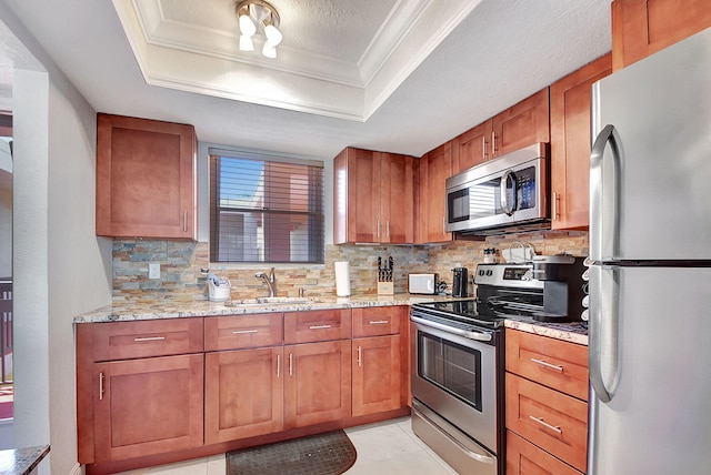 kitchen featuring stainless steel appliances, sink, tasteful backsplash, and a raised ceiling