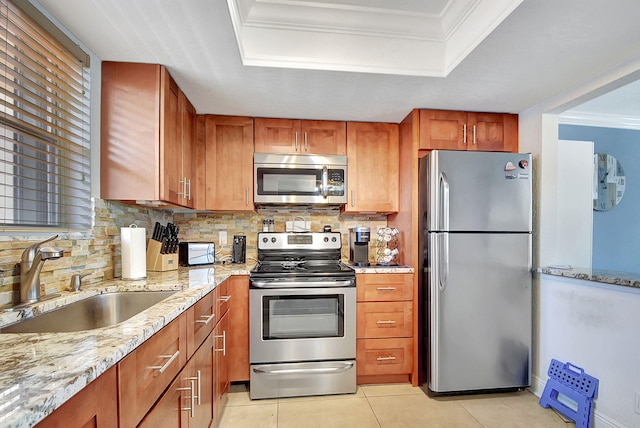 kitchen with sink, light tile patterned floors, appliances with stainless steel finishes, a raised ceiling, and backsplash