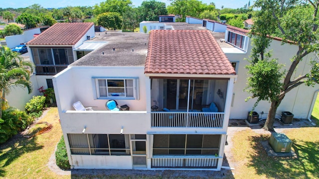 back of property featuring a sunroom and a lawn