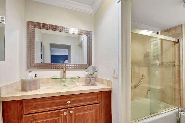 full bathroom featuring bath / shower combo with glass door, ornamental molding, vanity, and toilet