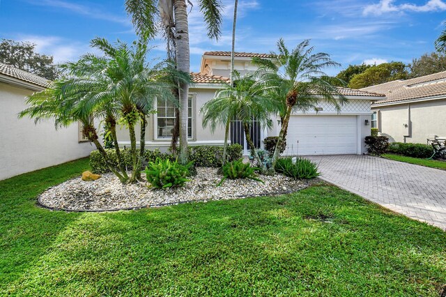 mediterranean / spanish-style home with a garage and a front lawn