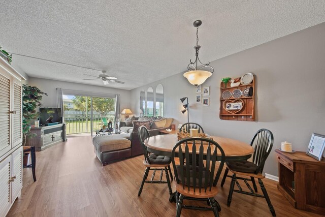 dining room featuring ceiling fan, light hardwood / wood-style floors, and a textured ceiling