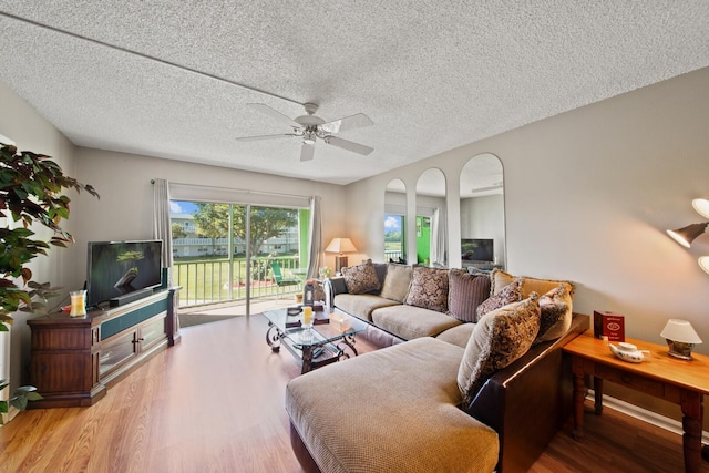 living room featuring hardwood / wood-style flooring, a textured ceiling, and ceiling fan