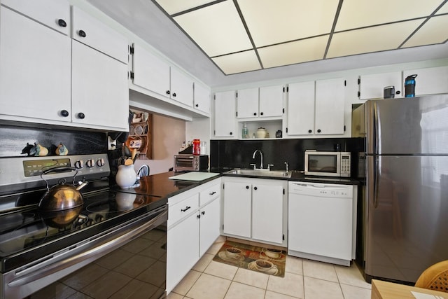 kitchen featuring white cabinetry, tasteful backsplash, stainless steel appliances, and light tile flooring