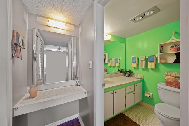 bathroom with toilet, tile flooring, vanity, ceiling fan, and a textured ceiling