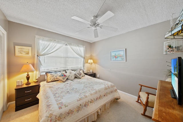 carpeted bedroom featuring a textured ceiling and ceiling fan