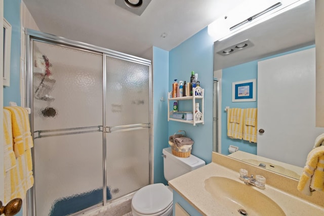 bathroom featuring walk in shower, toilet, and vanity with extensive cabinet space