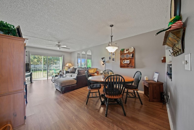 dining area with ceiling fan, a textured ceiling, and hardwood / wood-style flooring