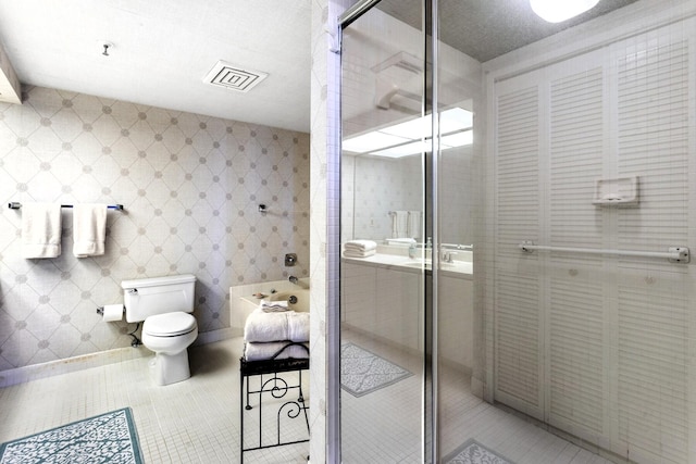 bathroom with shower with separate bathtub, toilet, and tile patterned floors