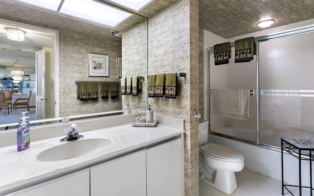 full bathroom with toilet, tile patterned flooring, vanity, and combined bath / shower with glass door