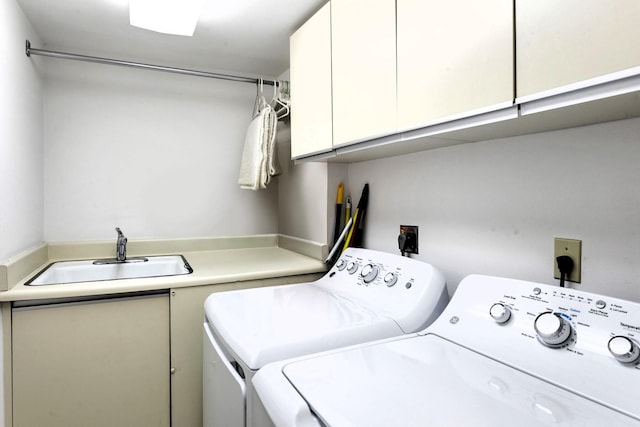 laundry room featuring cabinets, washing machine and dryer, and sink