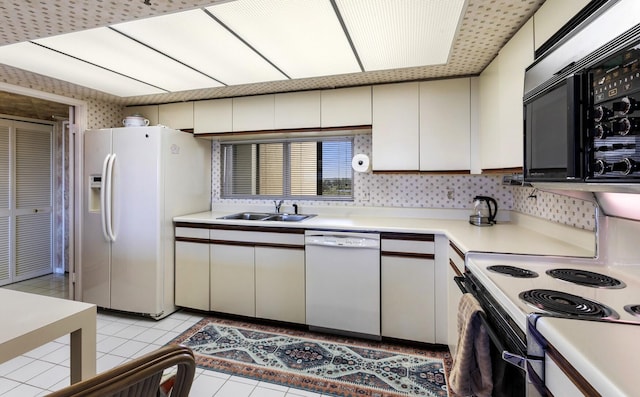 kitchen with white cabinetry, white appliances, sink, and light tile patterned floors