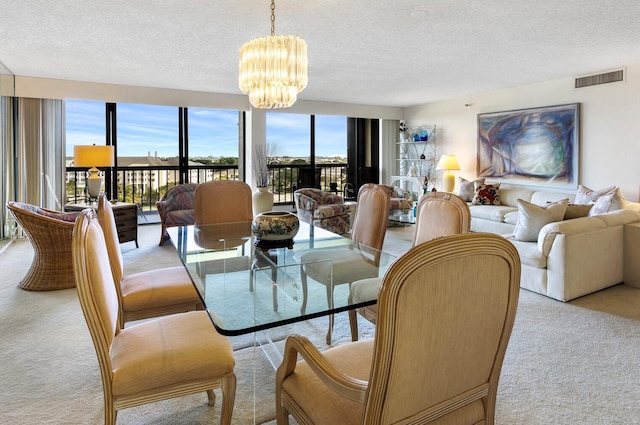 dining space featuring a textured ceiling, light colored carpet, and an inviting chandelier