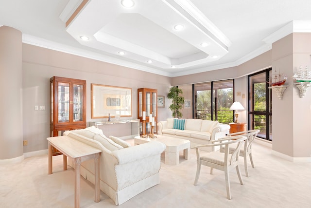 carpeted living room with a tray ceiling and ornamental molding