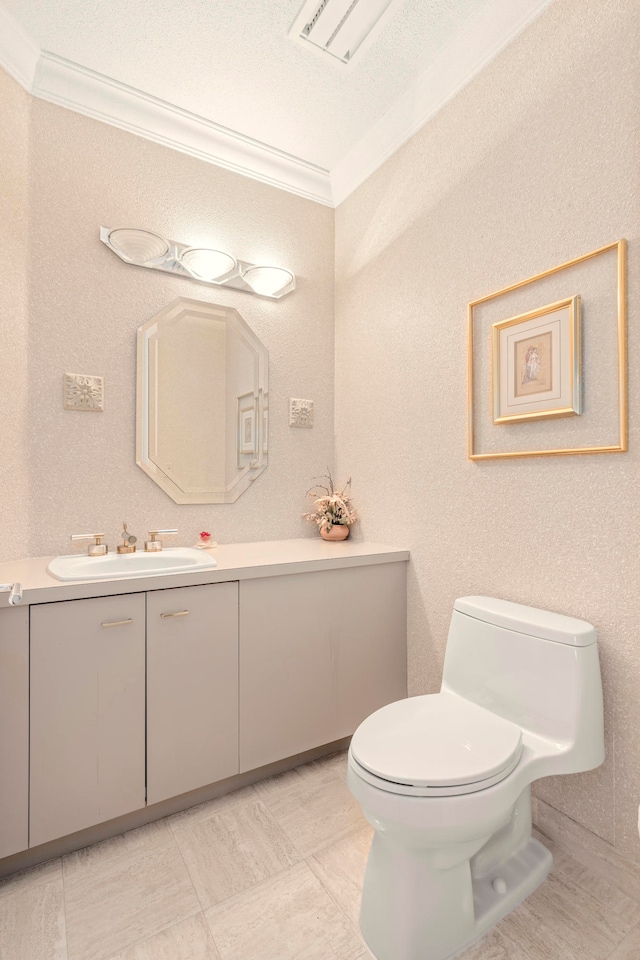 bathroom with a textured ceiling, vanity, toilet, and crown molding