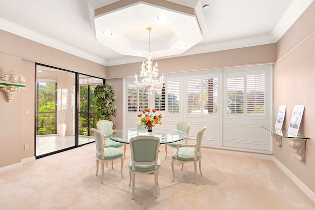 dining space featuring light carpet, plenty of natural light, crown molding, and a notable chandelier